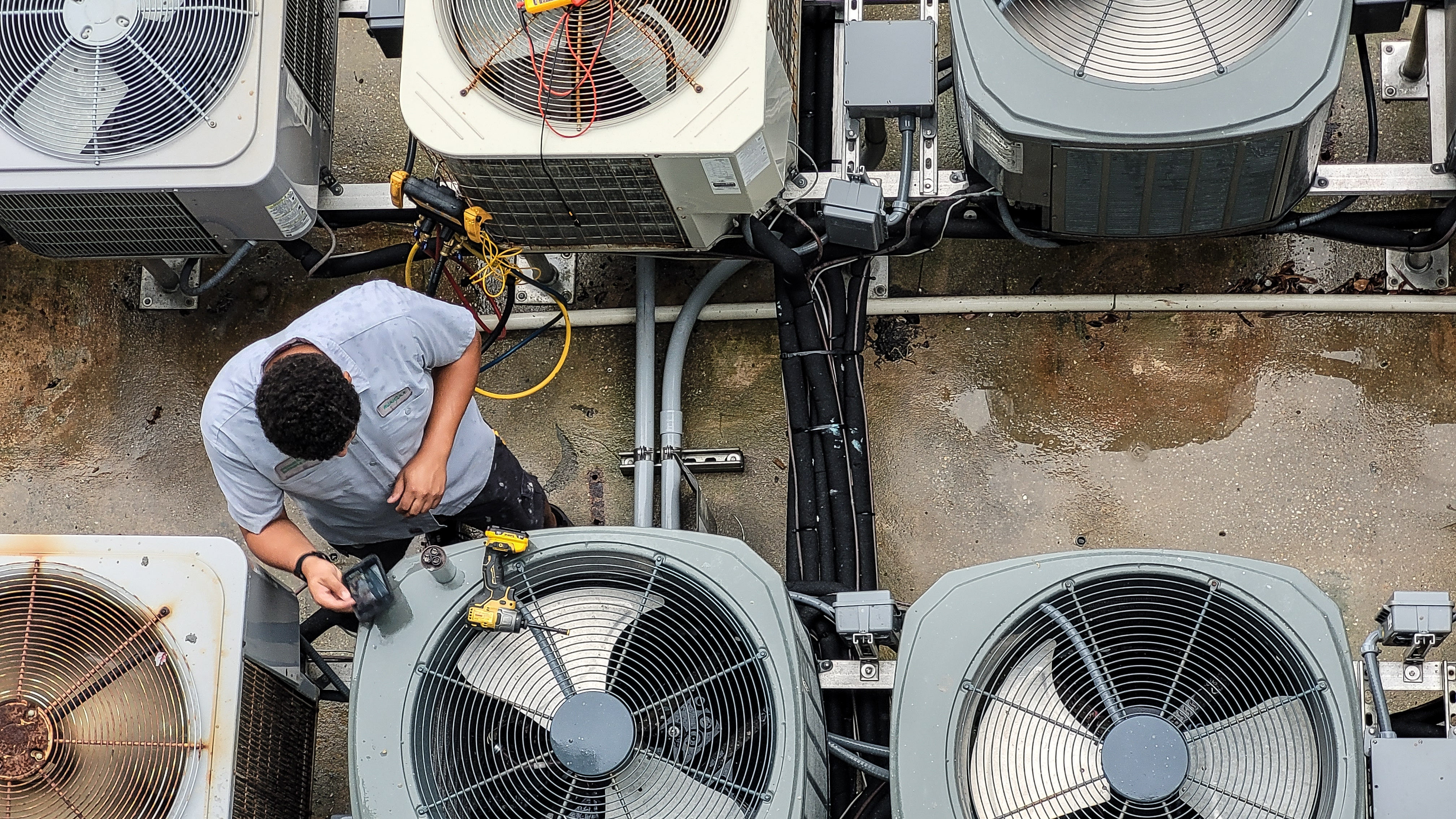 HVAC technician servicing outdoor air conditioning units